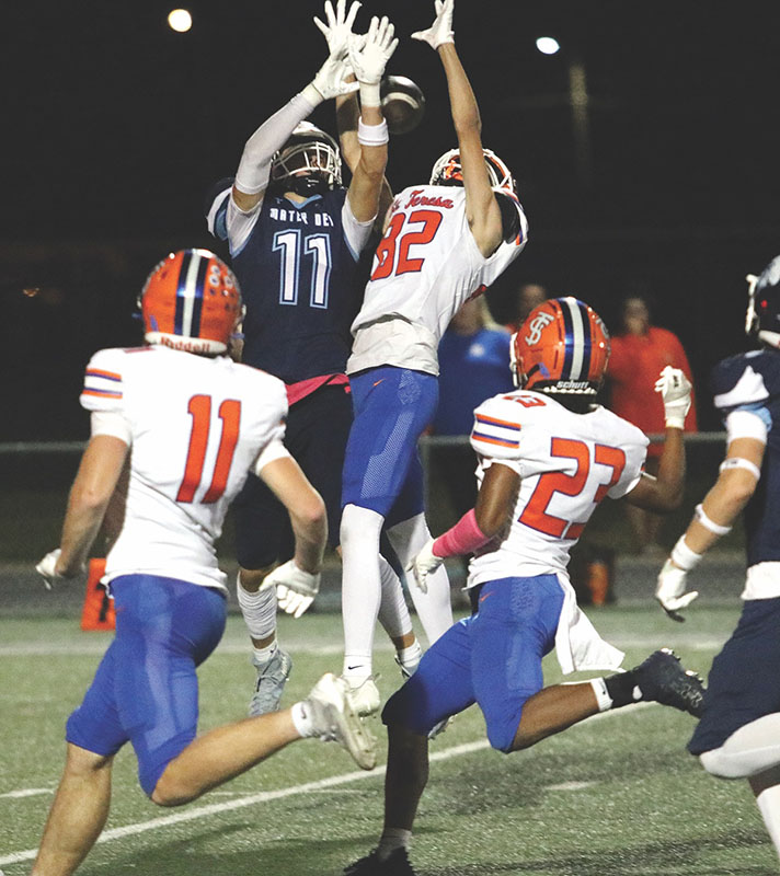 Jump ball — Mater Dei senior Beckett Wade elevates for a pass against the defense of St. Teresa’s KJ Kenison in the first half of the Knights 65-39 win over the Bulldogs on Friday.  Wade had 68 yards receiving.                 PHOTO BY JEREMY CHAWGO WadeCC